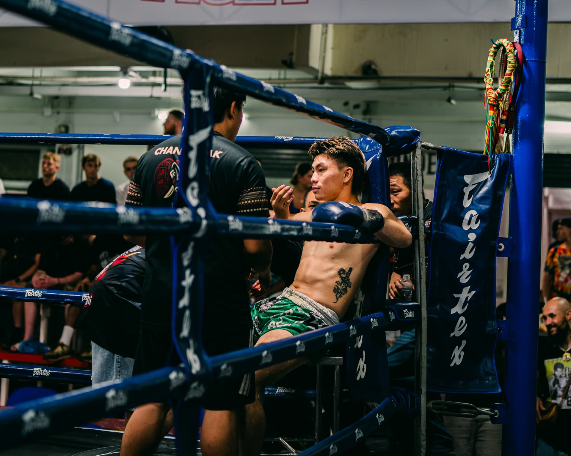 Fighter resting in the corner between rounds talking with his coach