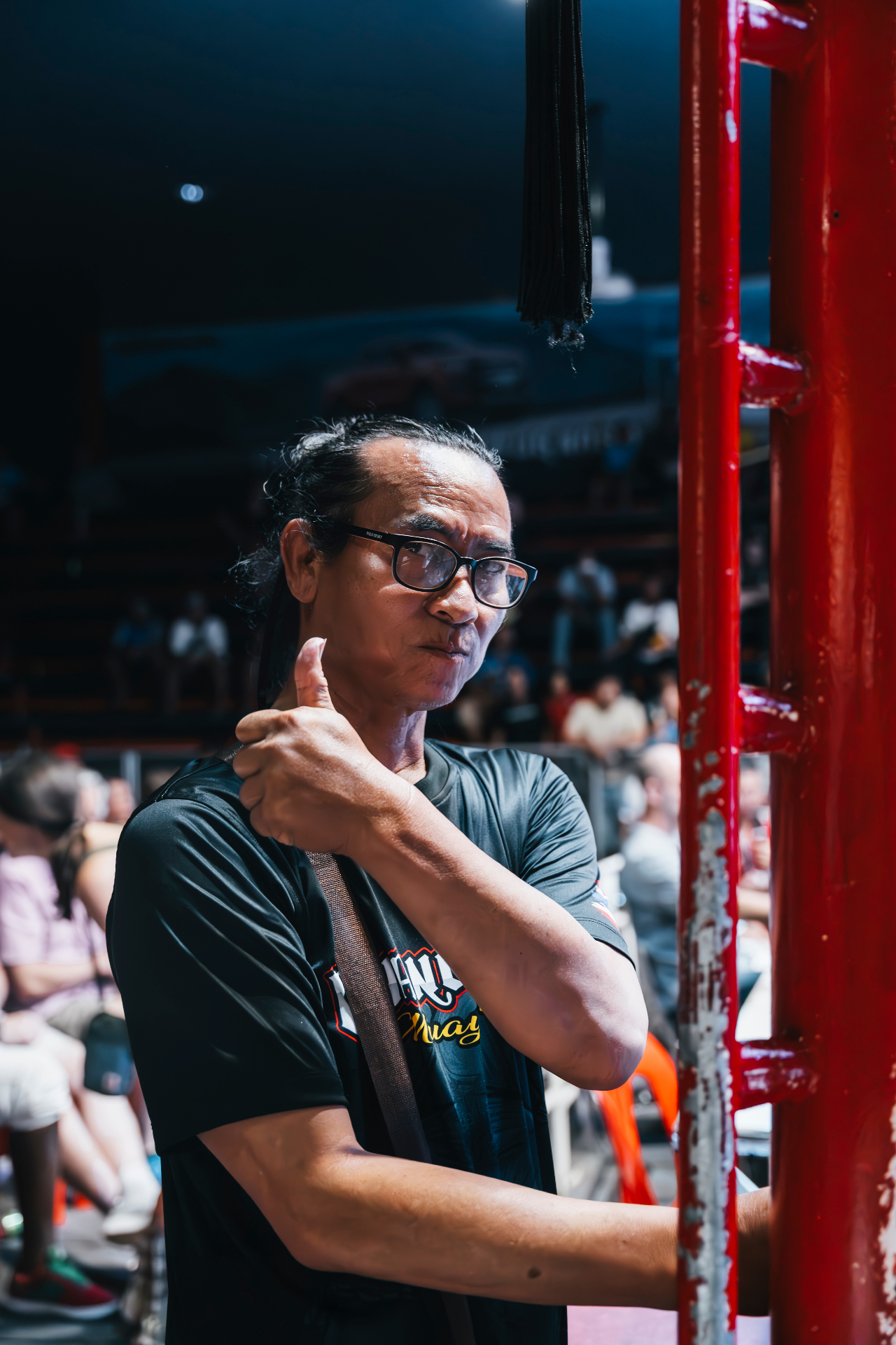 Head coach giving a thumbs up ringside at the stadium