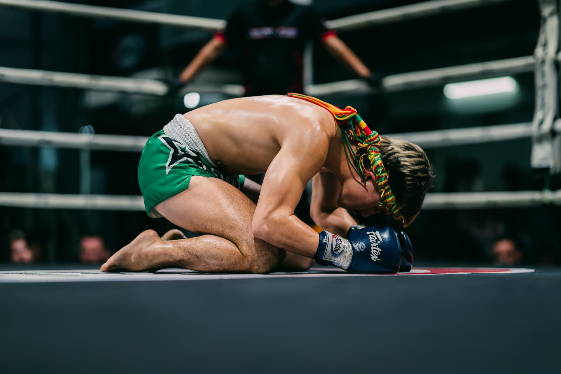 Fighter performing the Wai Khru ritual kneeling in the ring before the fight