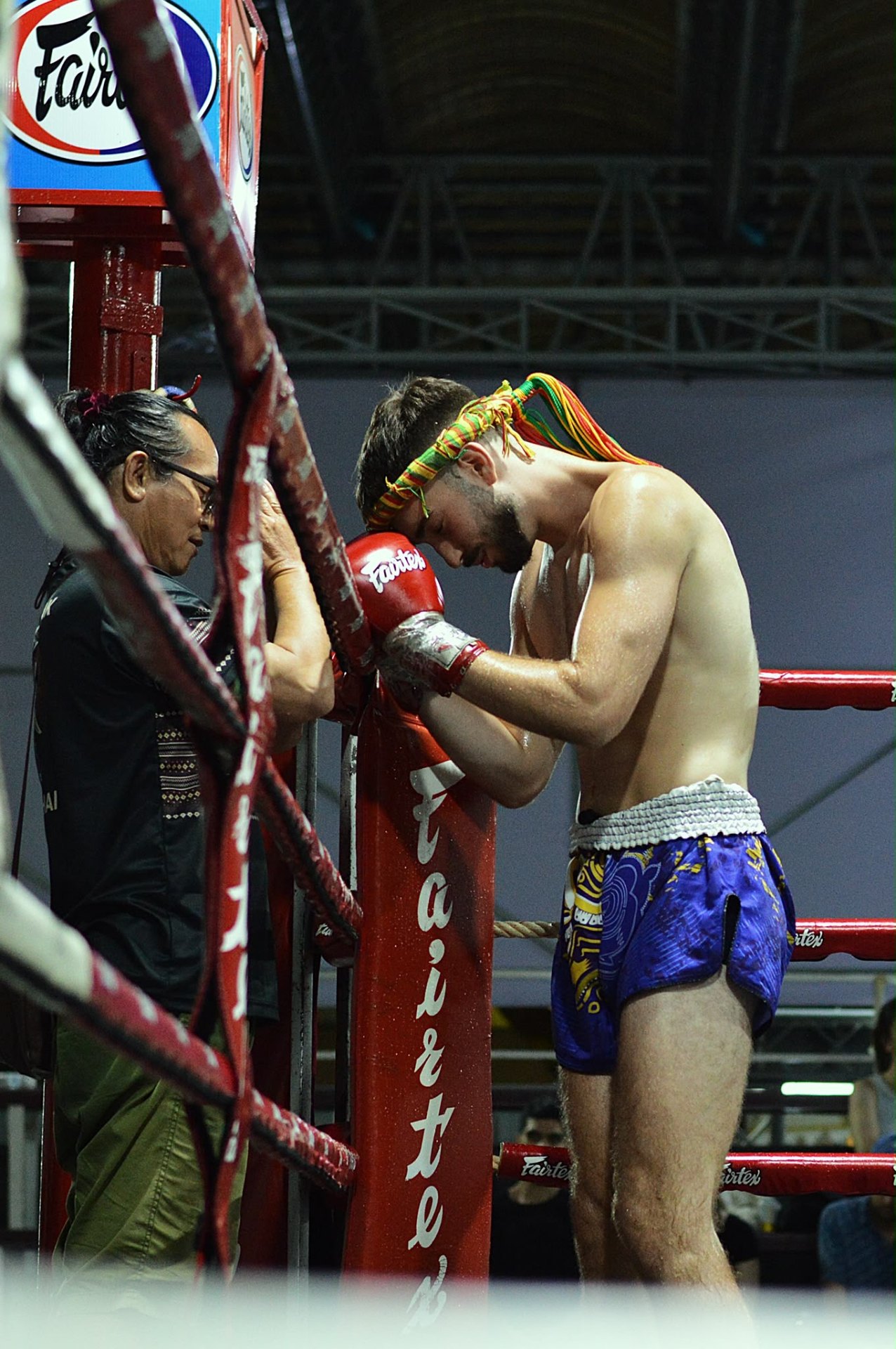 Fighter with mongkol in the corner surrounded by team at Thapae stadium
