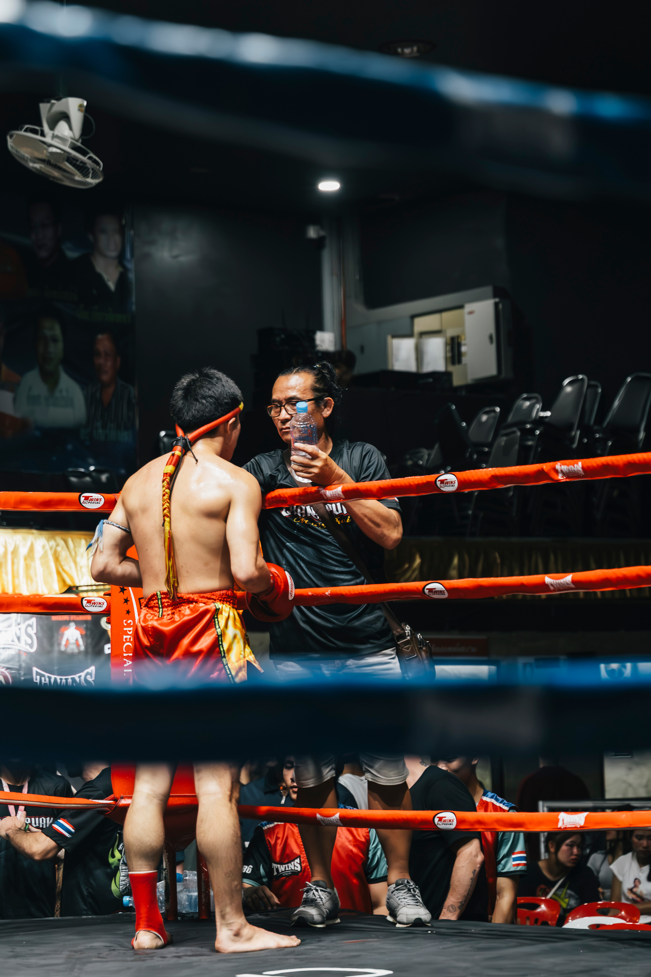Coach giving water to fighter between rounds in the corner