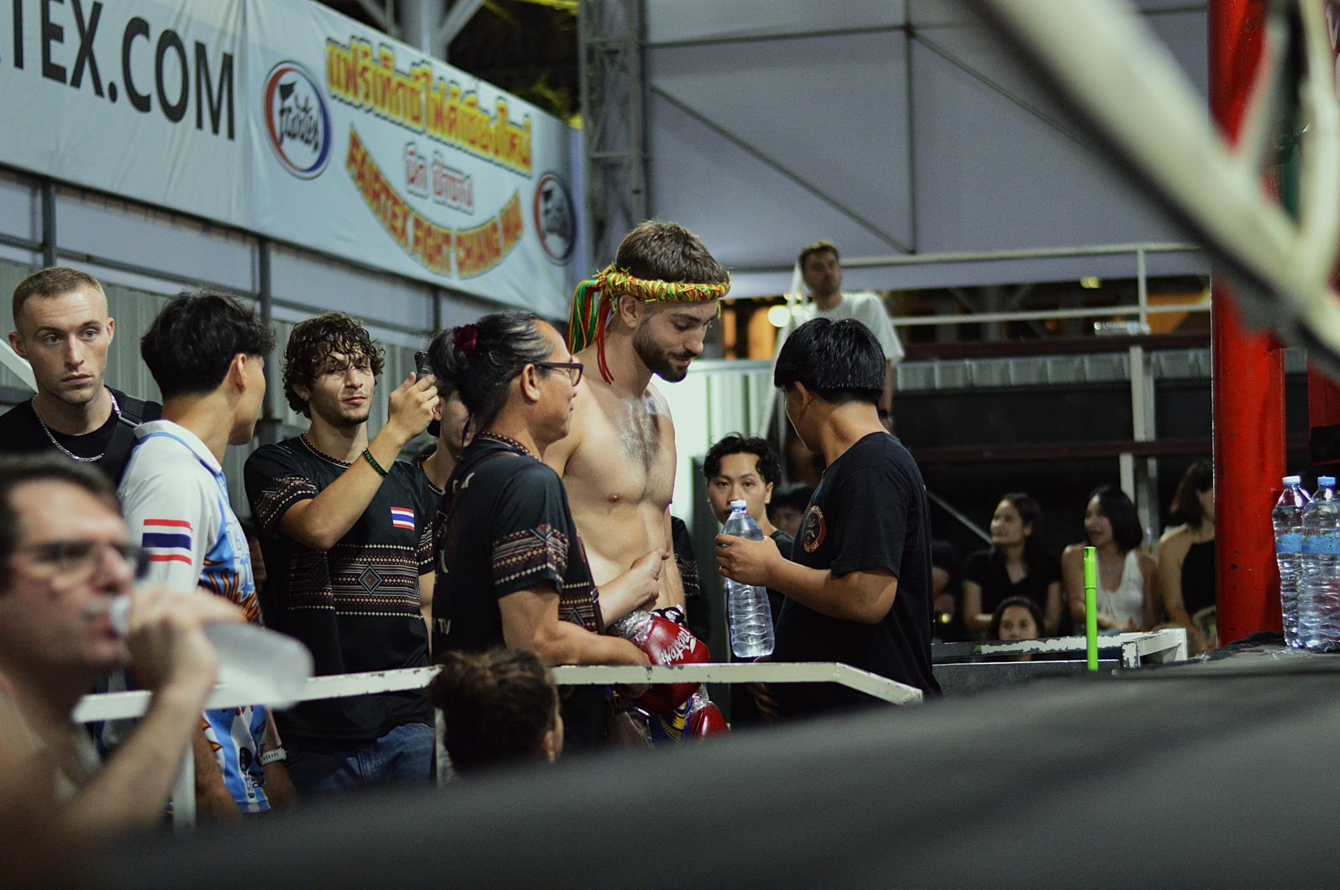 Fighter with mongkol in the corner surrounded by team at Thapae stadium