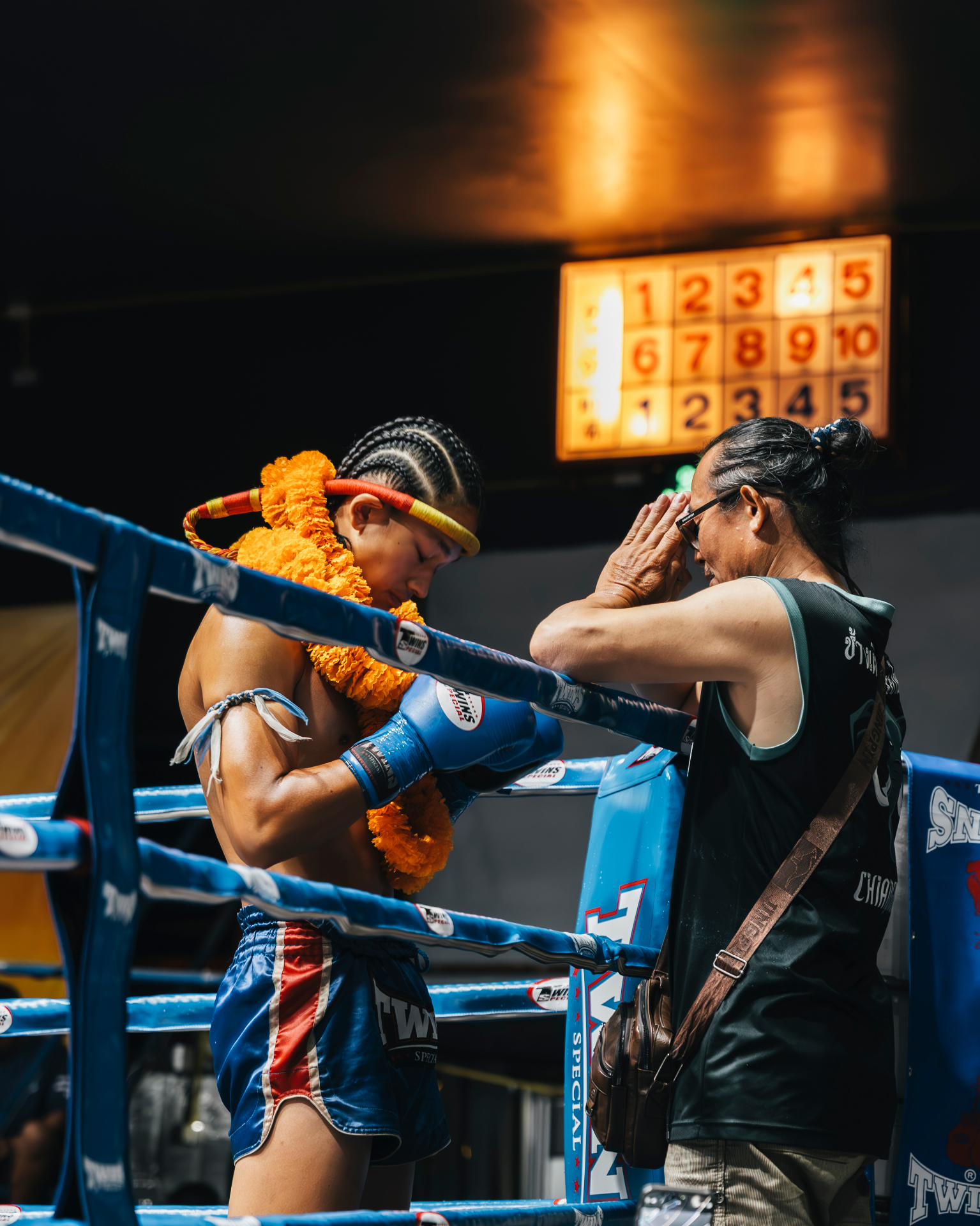 Trainer blessing fighter with mongkol before the fight