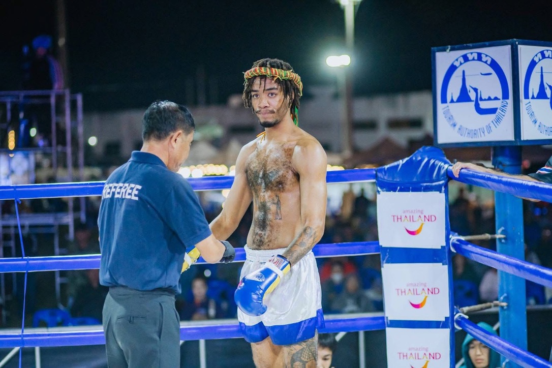 Fighter with mongkol speaking with the referee in the ring