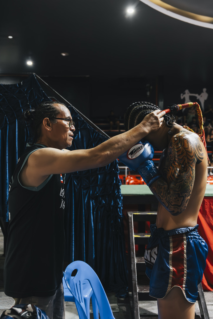 Coach placing the mongkol on the fighter's head