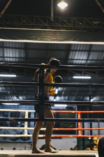 Fighter alone in the corner of a Thai ring at night